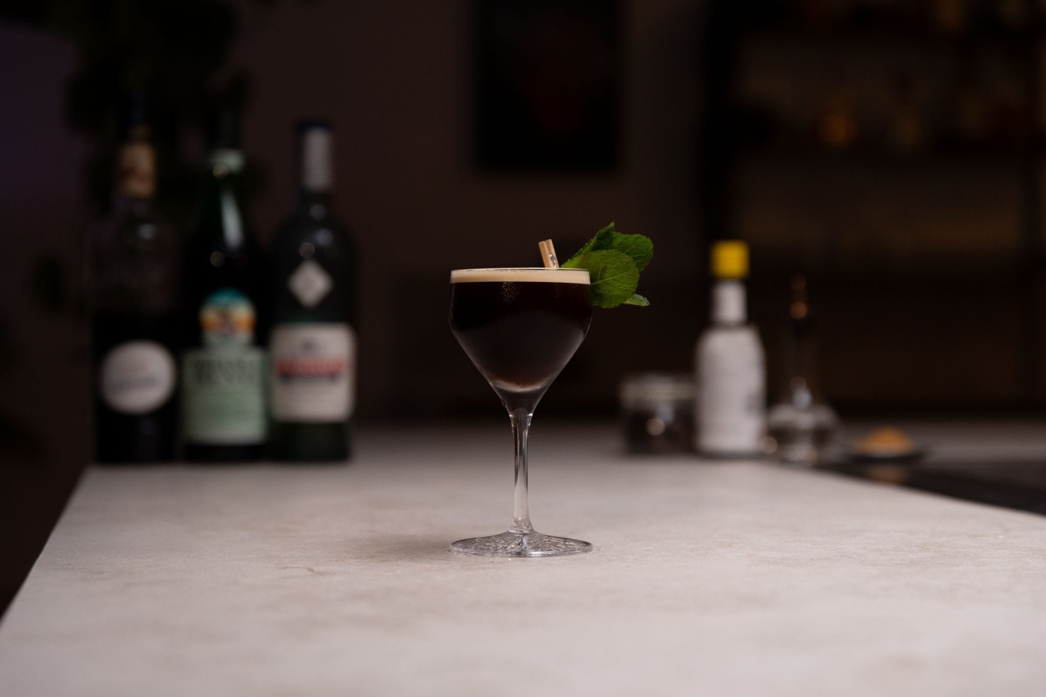 Brancamenta, absinthe, coffee liqueur, espresso, brown sugar syrup, Angostura bitters and saline solution laid out on a white bar table