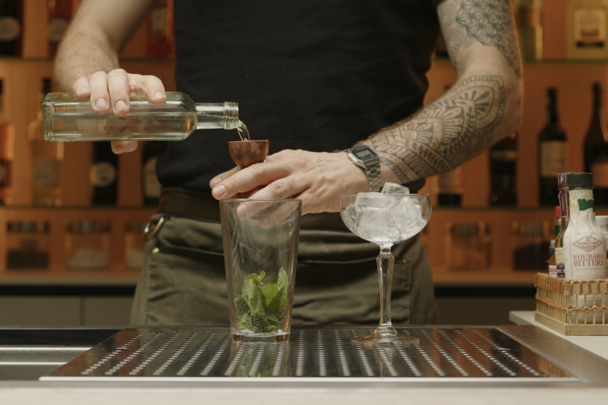 Simple syrup poured into shaker with jigger