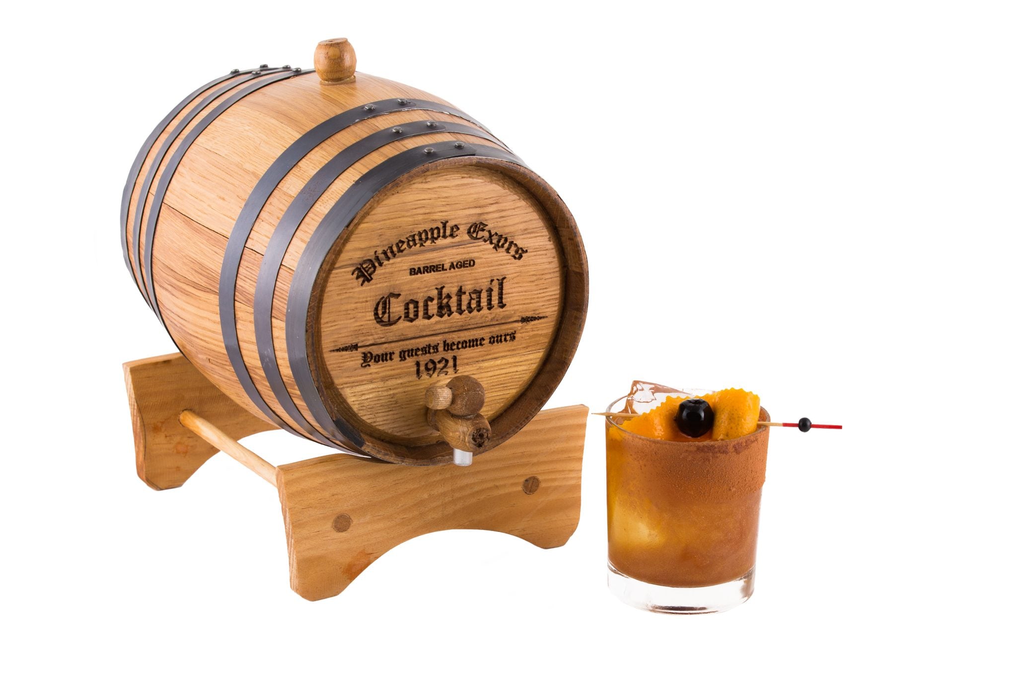 A shot of a barrel with Pineapple Express Cocktail inside and a low ball glass filled with the cocktail, on a white background