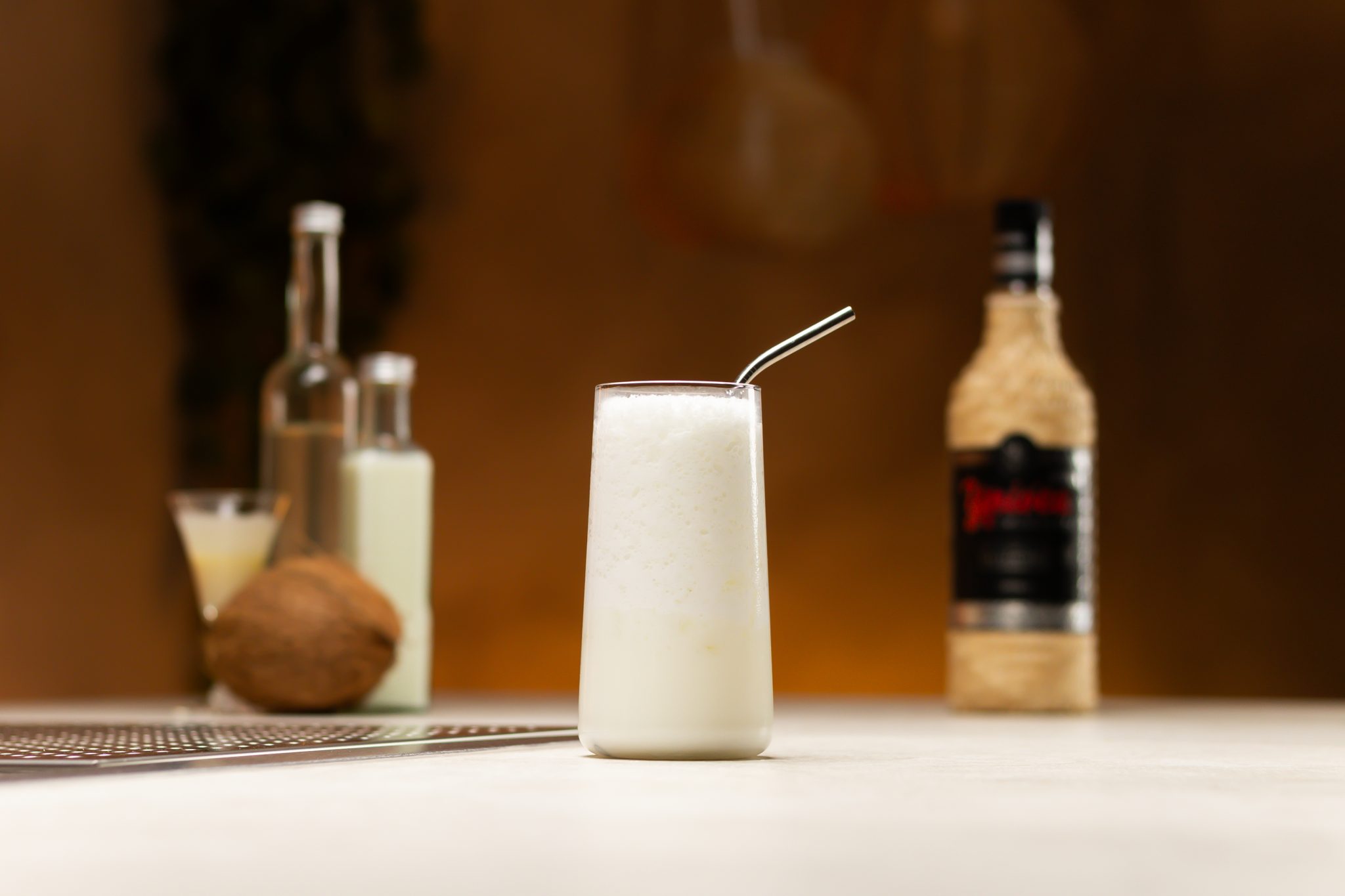 Cachaca, condensed milk, coconut milk, coconut water, and coconut laid out on a white bar table