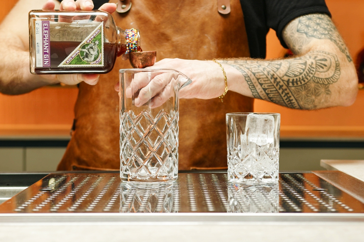 <p>Pour one ounce of sloe gin into the mixing glass. The sloe gin will give the cocktail a fruity, slightly sweet taste.</p>
