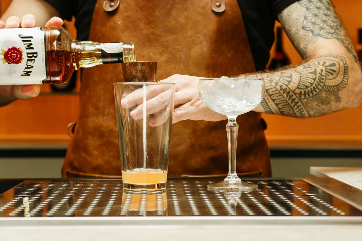 <p>Finally, pour 2 ounces of bourbon into the shaker.</p>
