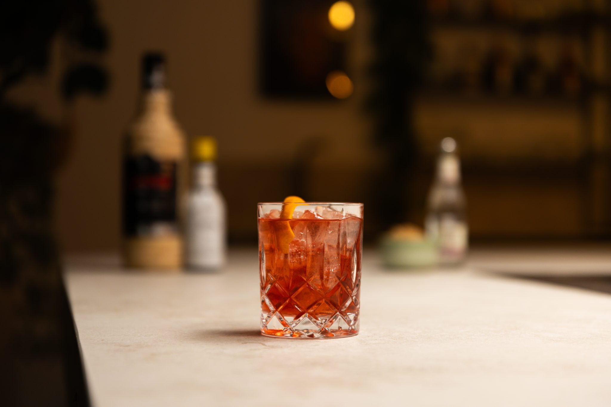 Cachaça, powdered Demerara sugar in a bowl, Angostura aromatic bitters and soda laid out on a white bar table