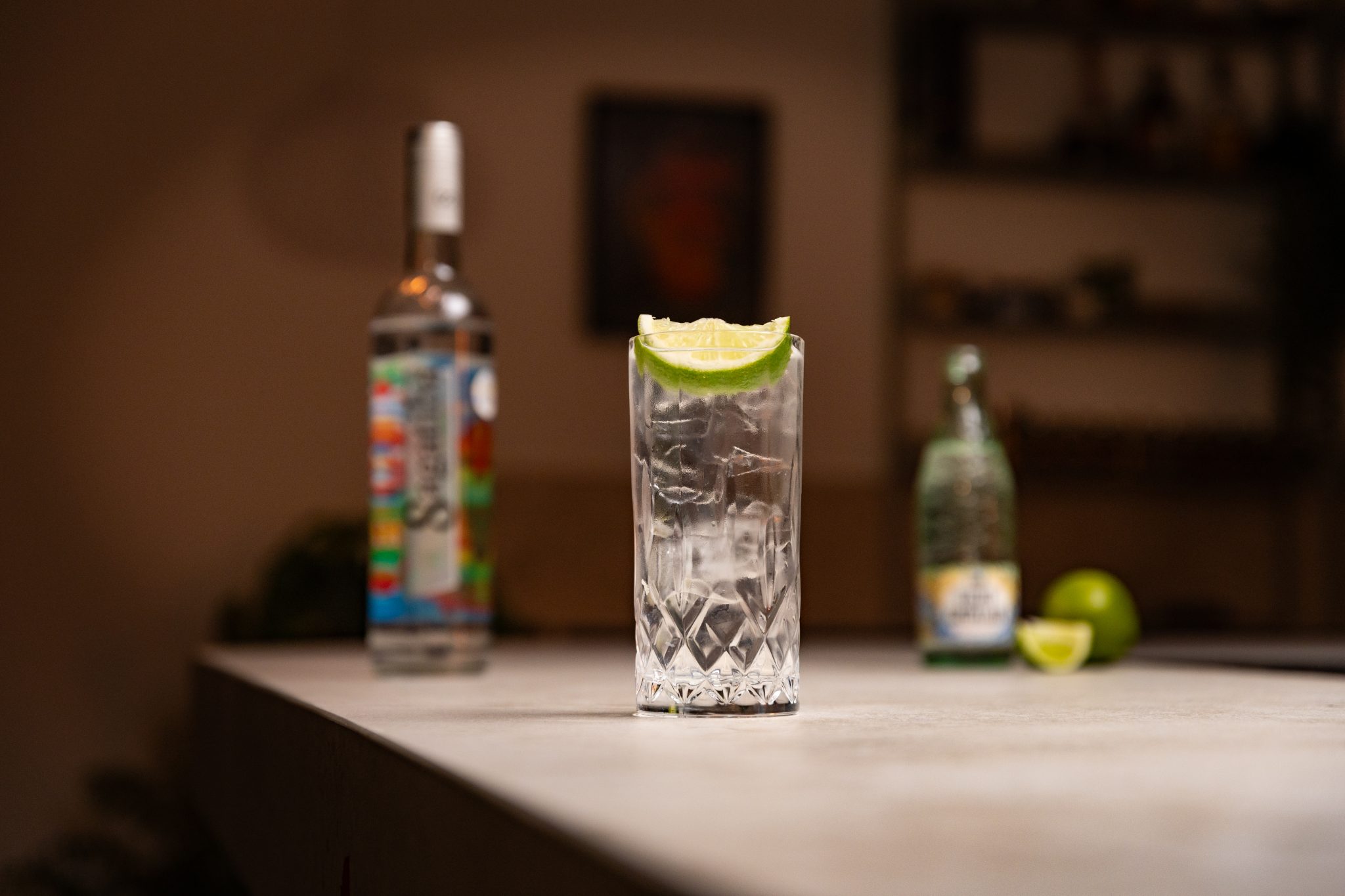 Cachaça, soda and lime laid out on a white bar table