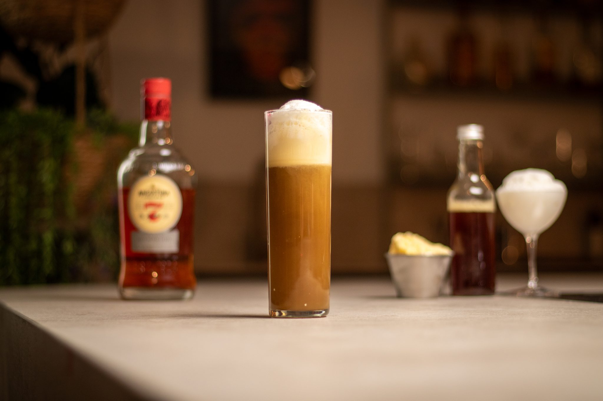 Dark Rum, root beer, vanilla ice cream, and whipped cream laid out on a white bar table