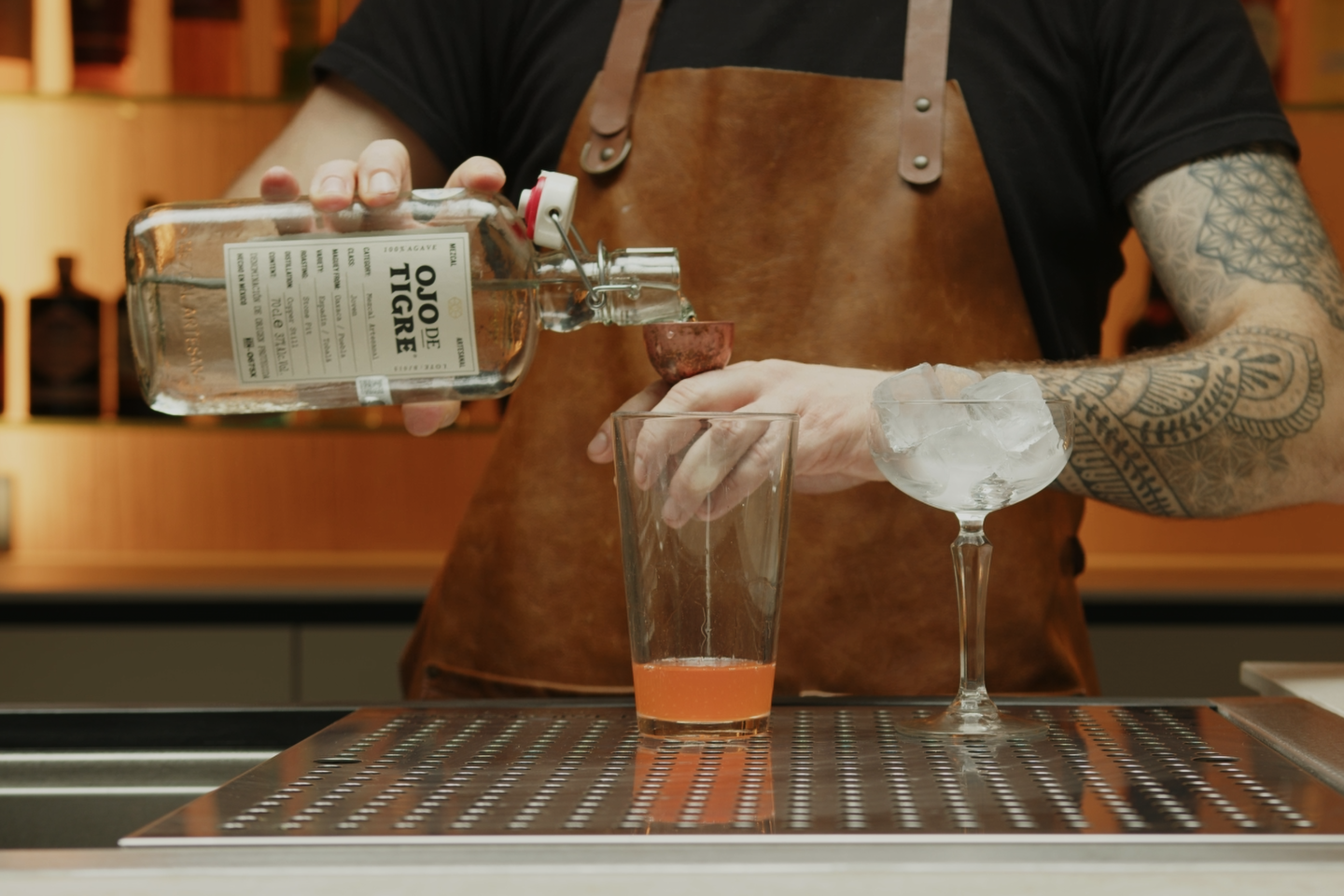 <p>Pour 1 oz of Mezcal into the shaker. The smoky flavor of Mezcal is a key component of this cocktail, providing a unique depth of flavor.</p>
