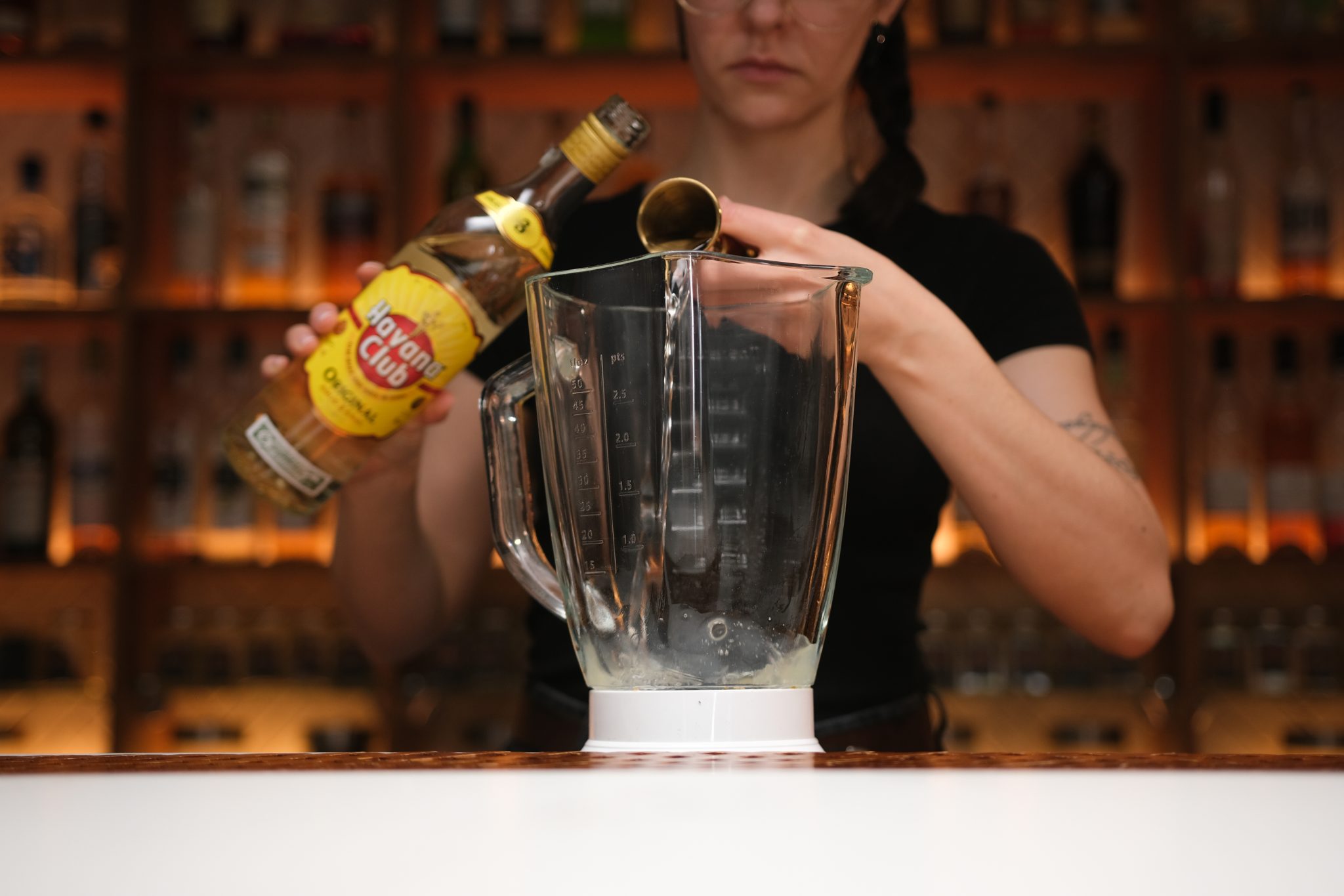 <p>Pour white Rum into the blender glass.</p>
