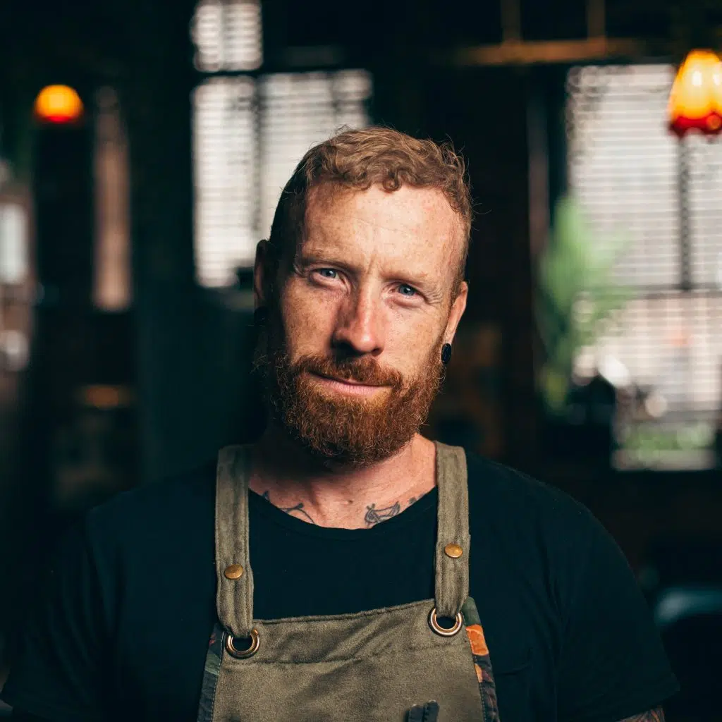 A shot of Gavin Wrigley looking to the camera in a dimly lit room