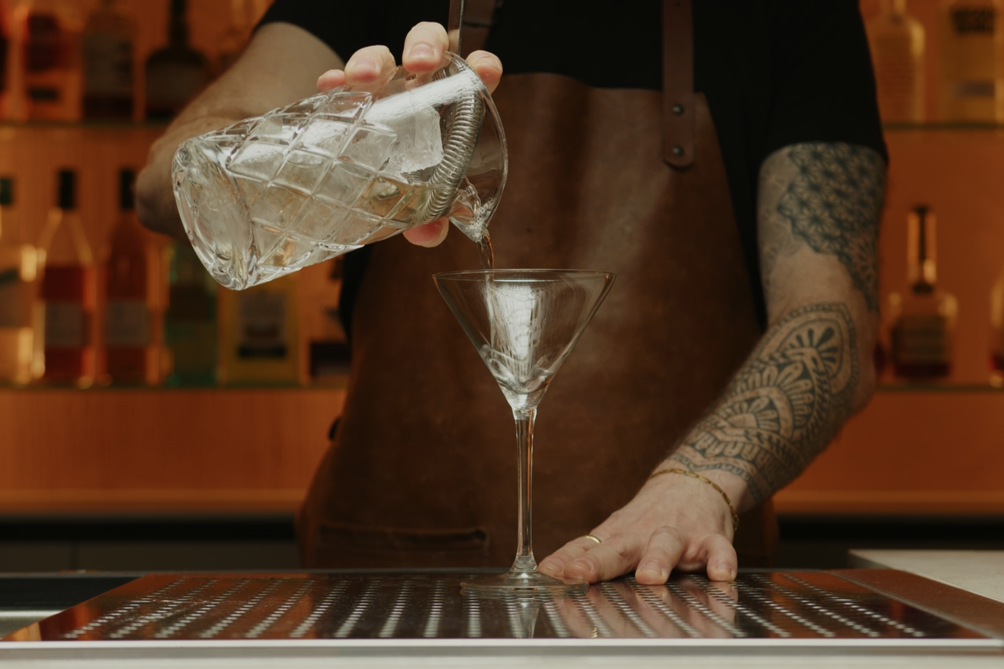 <p>Take your Martini glass or cocktail coupe and discard the ice. Using the cocktail strainer, strain the mixture into the chilled glass. This will remove the ice from the drink, preventing any further unwanted dilution to occur.</p>