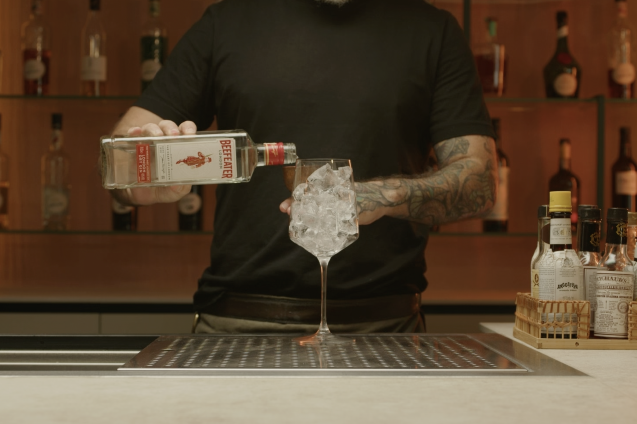 <p>Pour 2 oz of Gin over the ice, providing the botanical base for the cocktail.</p>