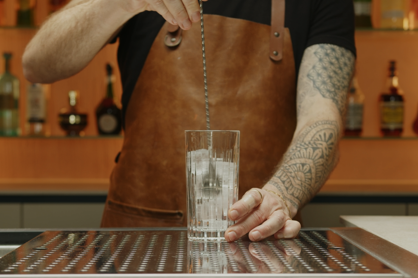 <p>Start by chilling a highball glass using some ice.</p>
