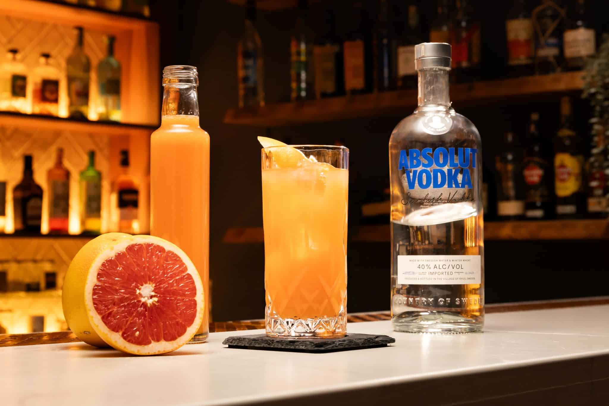 Vodka and grapefruit juice laid otu on a white bar table.