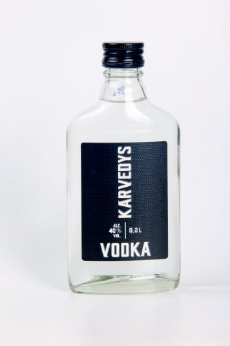 A side shot of a 200 mililiters bottle of Karvedys Vodka in front of a white background