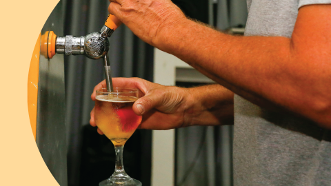 A shot of a person serving a beer using a tap