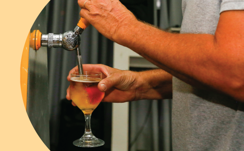 A shot of a person serving a beer using a tap