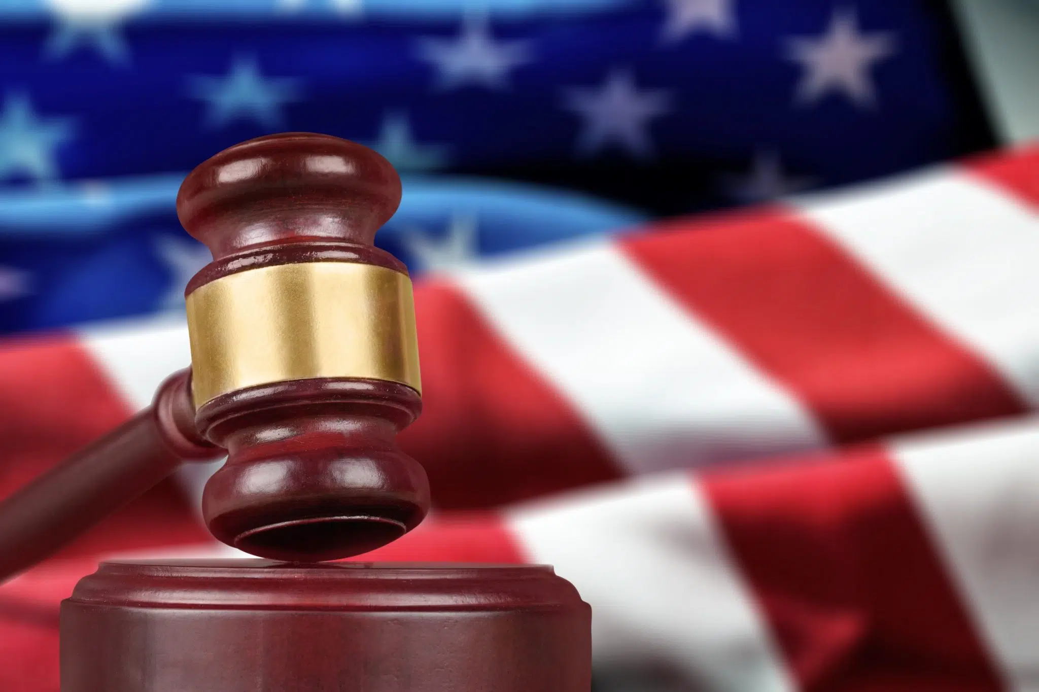 An image a judge gavel with a USA flag behind