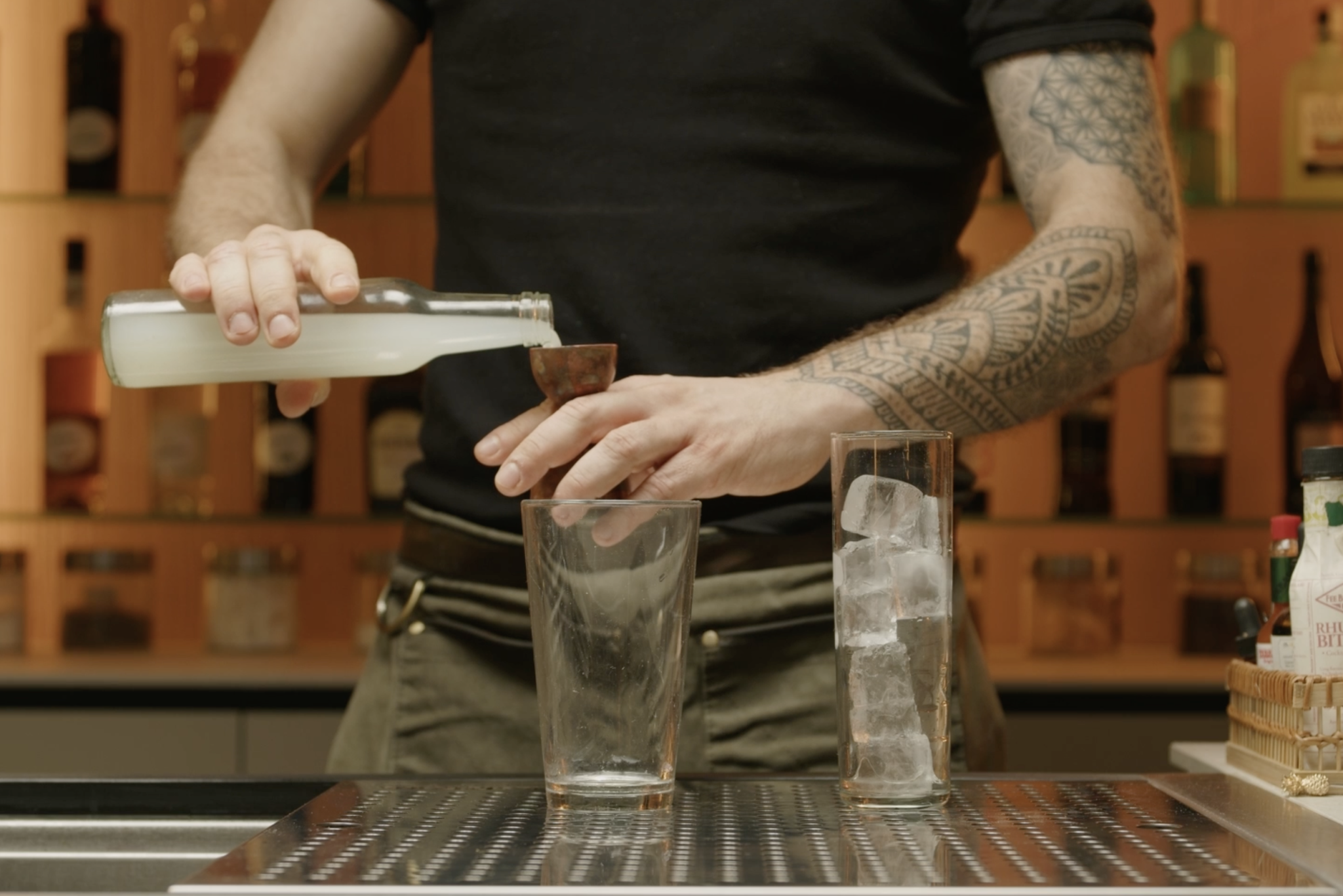 Lime juice poured into shaker with jigger