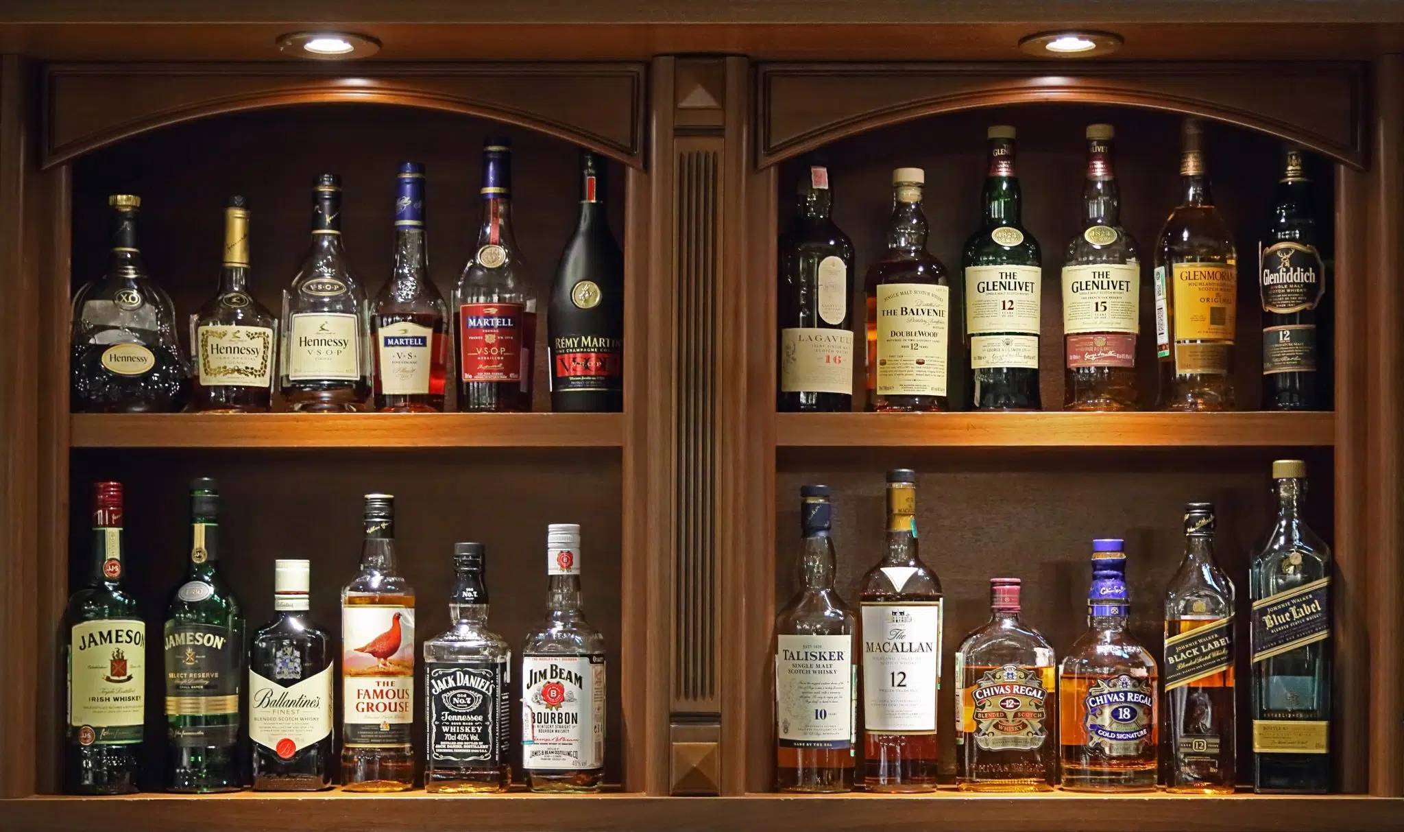 A shot of a liquor storage with the bottles side by side, upright, away from sunlight and in a cool location