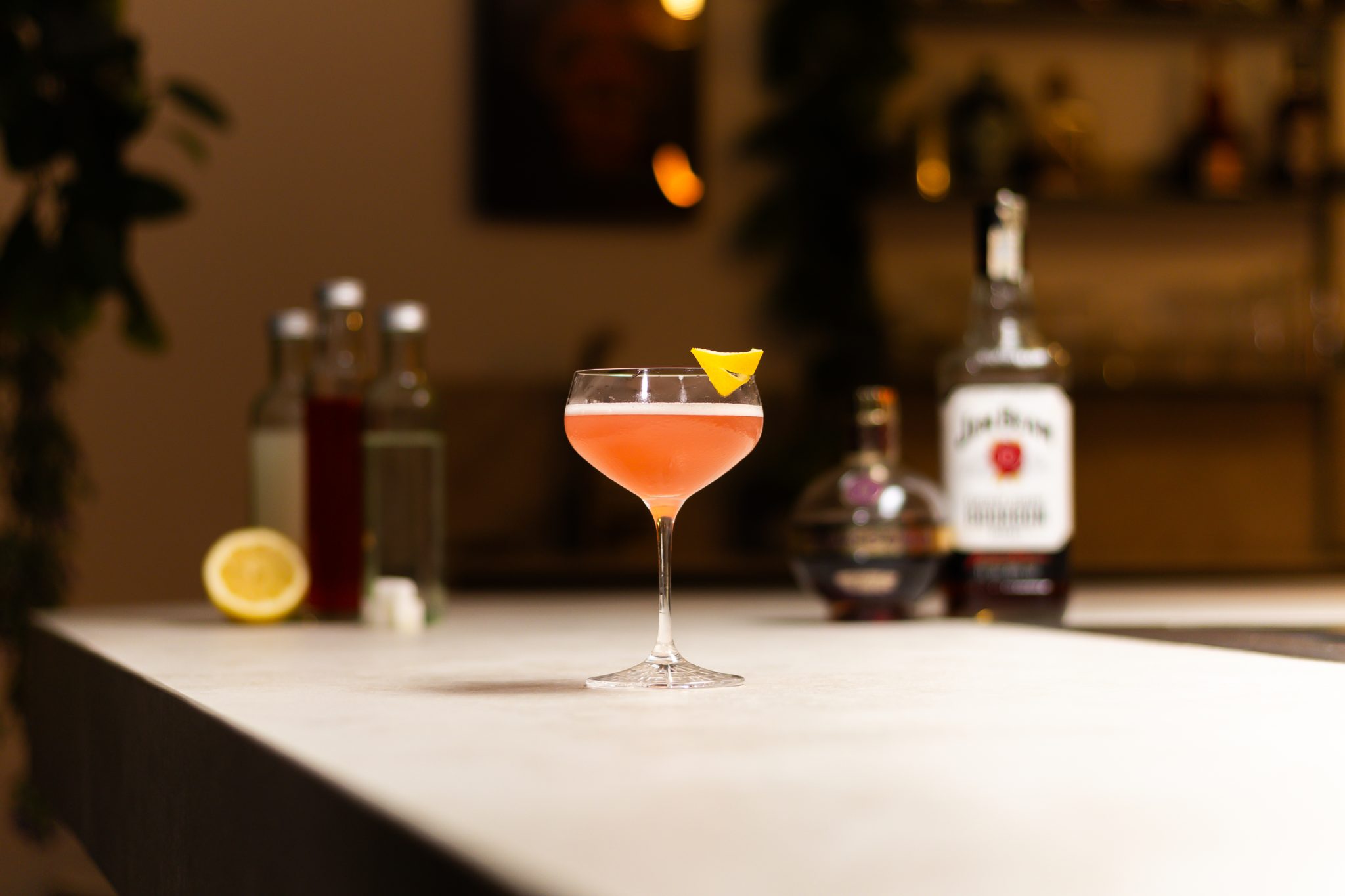 Bourbon, Chambord, cranberry juice, lemon juice, lemon and sugar syrup laid out on a white bar table