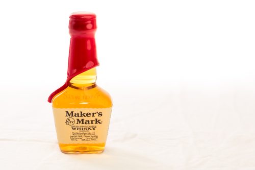 A side shot of a miniature bottle with 50 mililiters of a Maker's Mark spirit