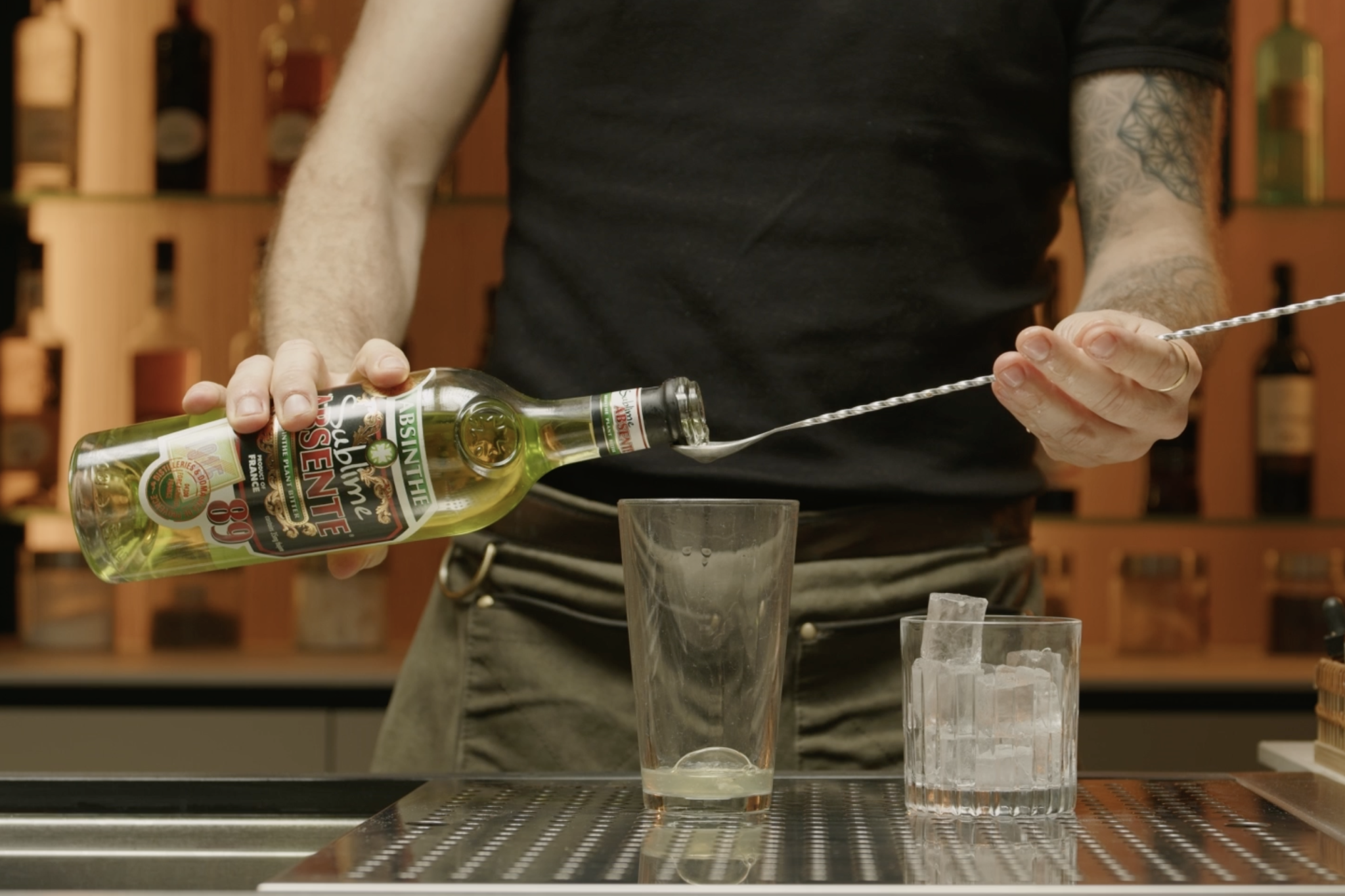 <p>Next, pour 1 bar spoon of absinthe into the shaker. This small amount will introduce a subtle anise flavor, adding depth to the cocktail without overwhelming the other ingredients.</p>
