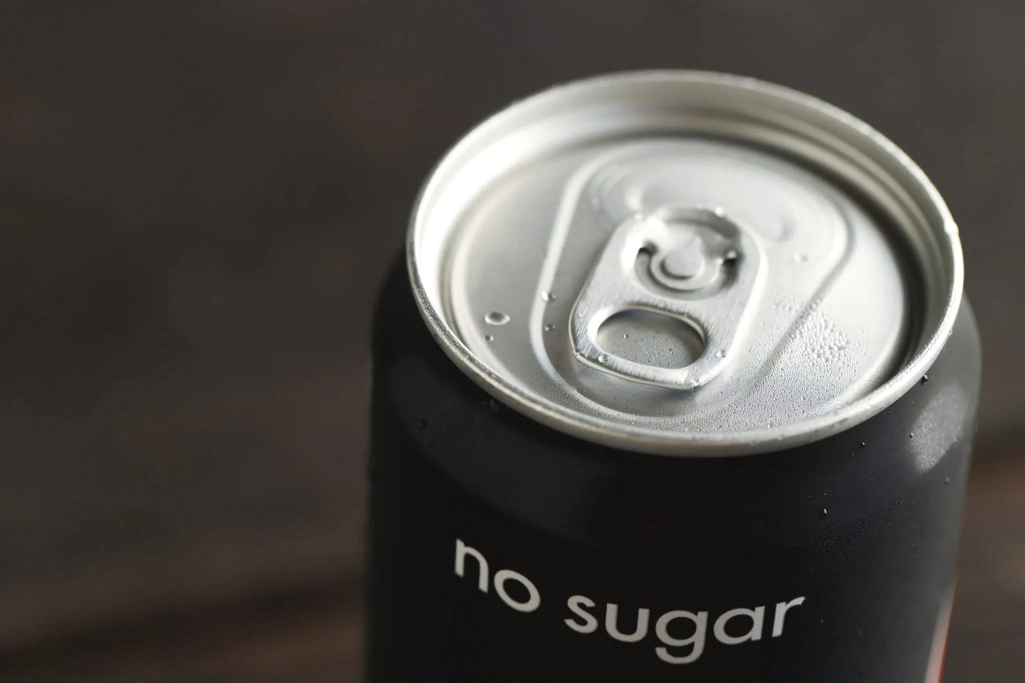 A shot of a black can with 'no sugar' written on it