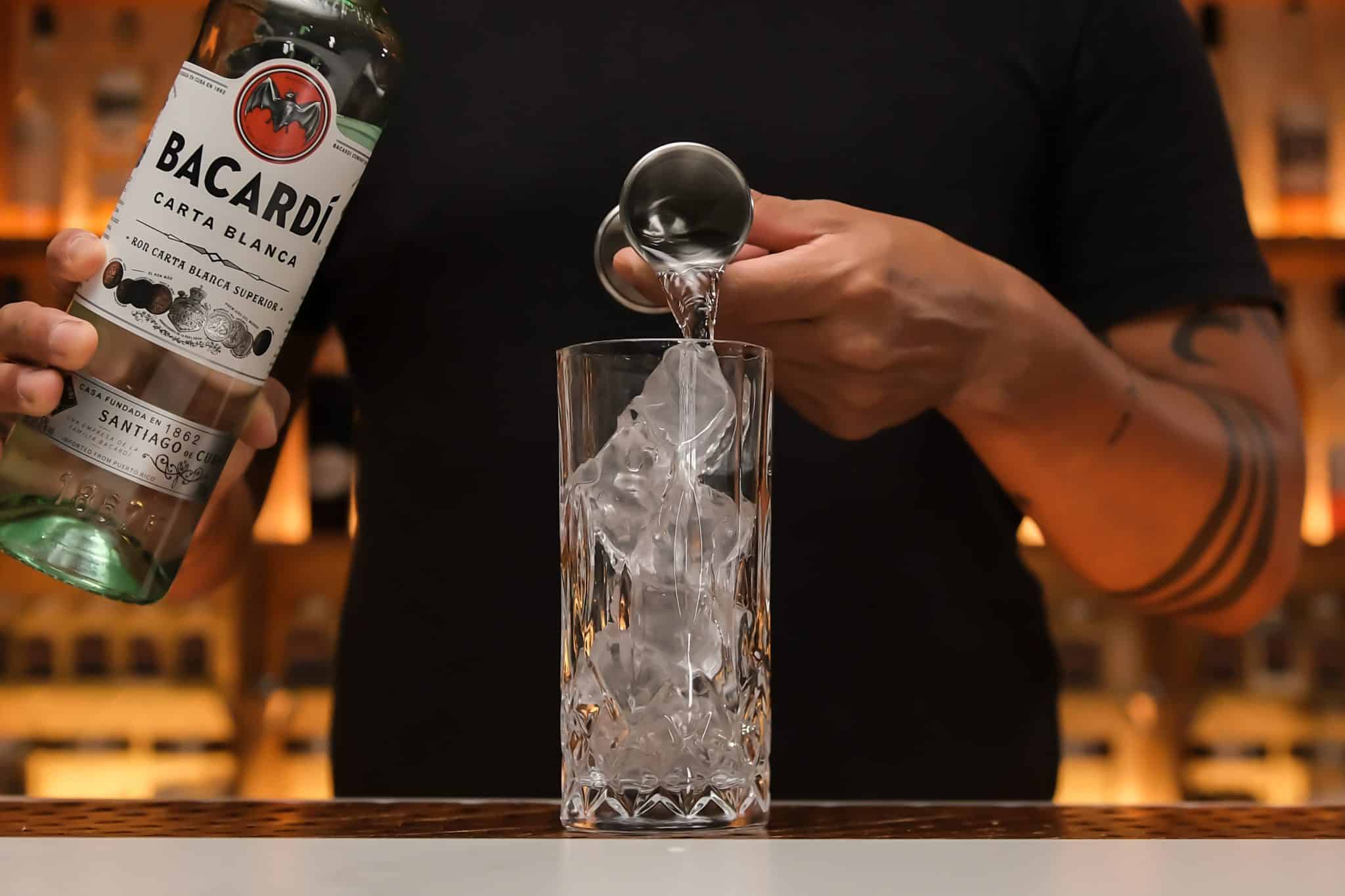 <p>Pour your desired amount of rum over the ice, typically starting with 2 ounces for a standard serving.</p>
