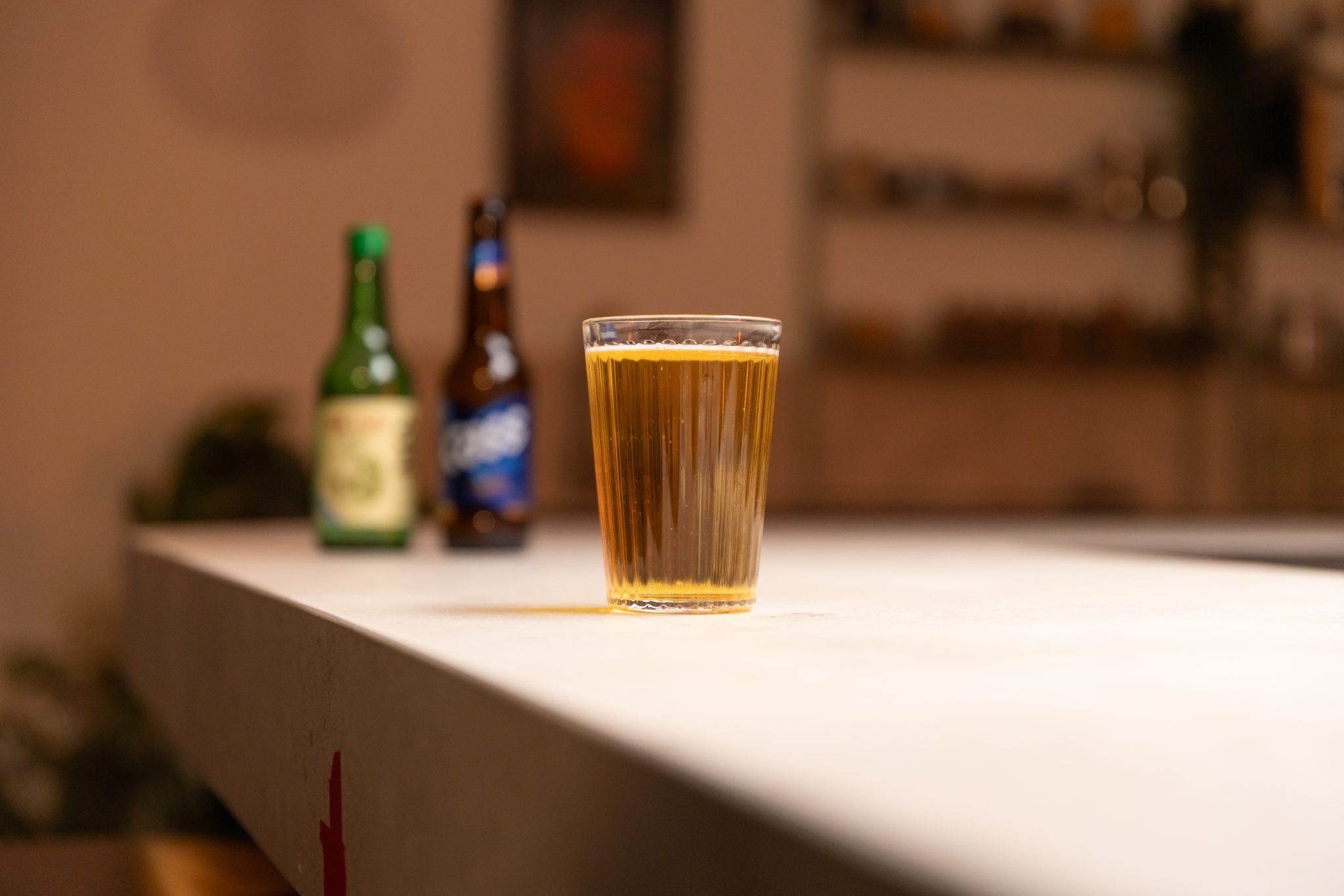 Soju and light beer laid out on a white bar table