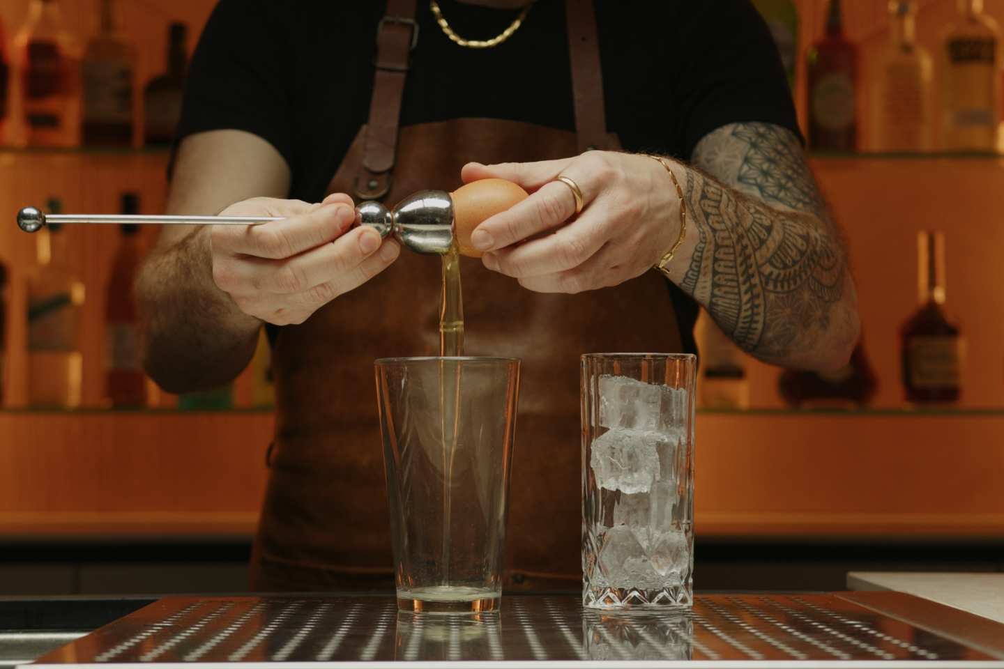 <p>Next, crack open an egg and carefully separate the white from the yolk, pouring the egg white into your cocktail shaker and discarding the yolk. This step is optional: the addition of egg white won’t alter the taste of the cocktail, but it will give it a frothy texture and create a soft foam on top of the drink.</p>