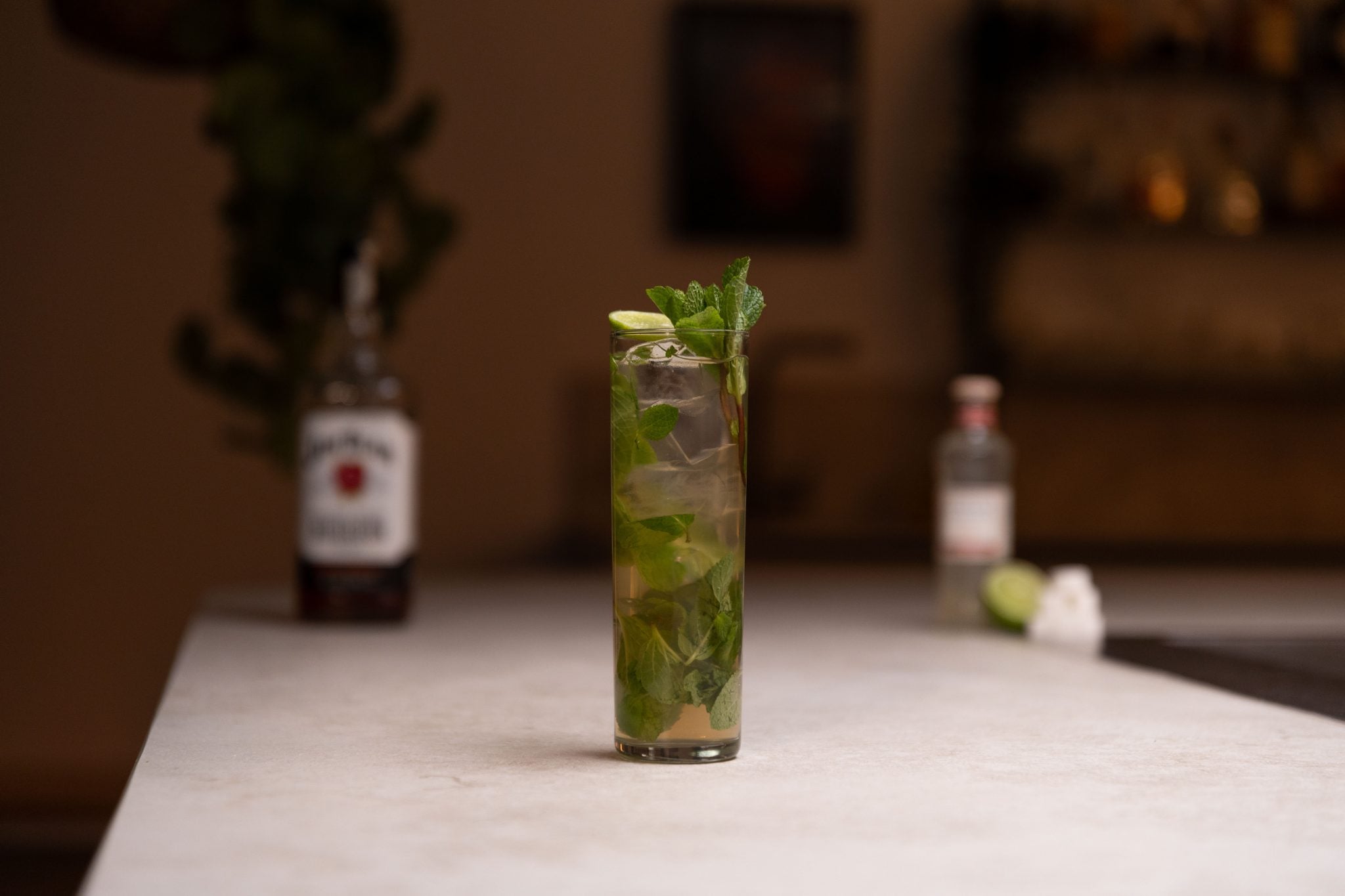 Bourbon, ginger beer, limee, sugar cubes and ginger beer laid out on a white bar table