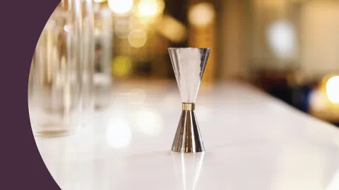 A shot of a jigger on a white bar table
