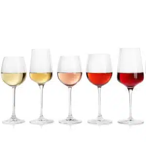 A side shot of wine glasses filled with different types of wines on a white background.