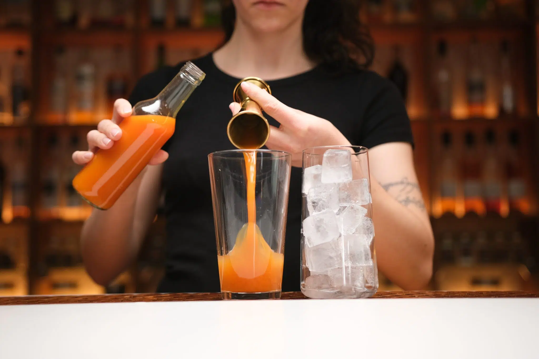 Papaya juice poured into shaker with jigger