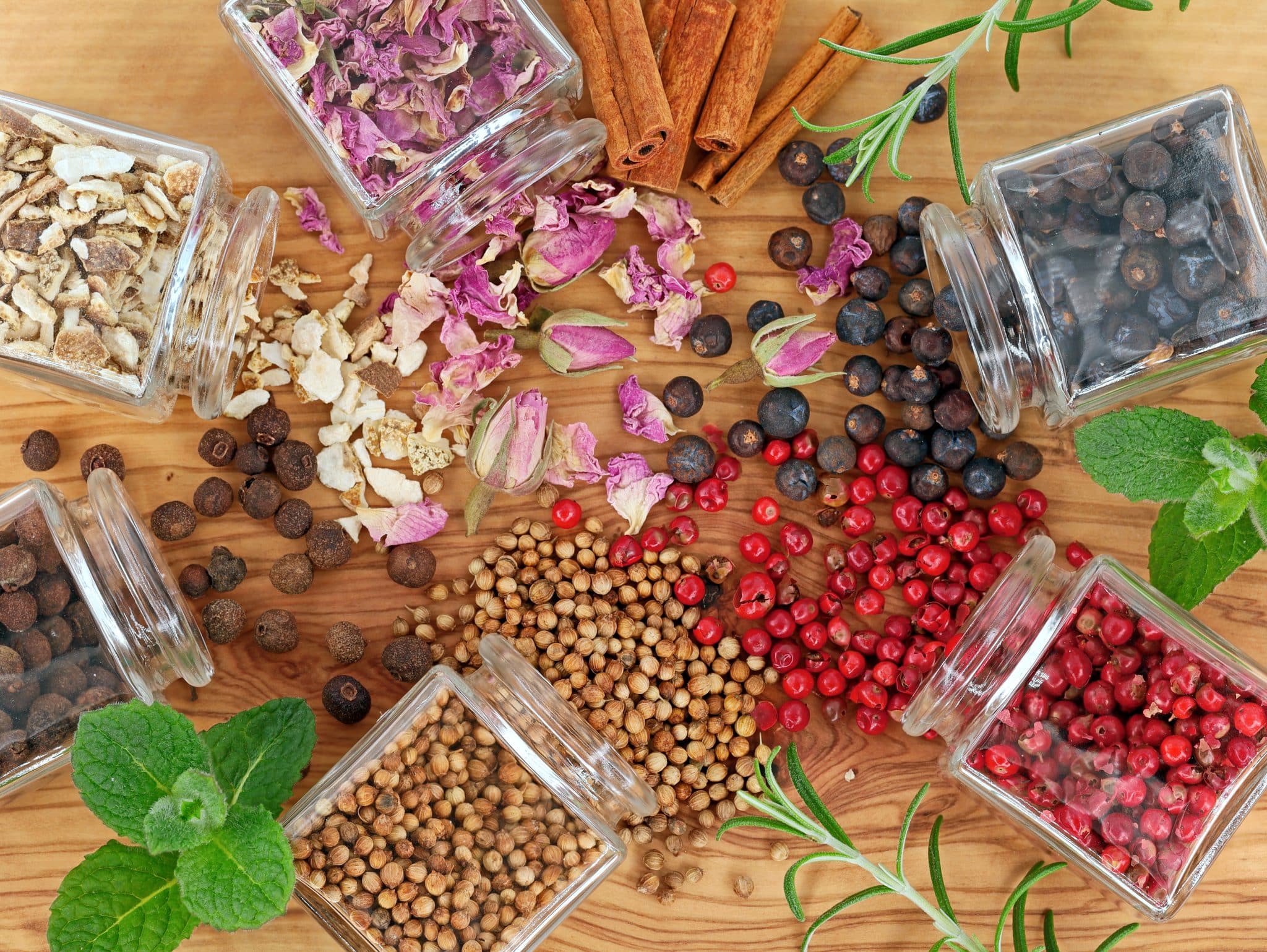 Top view of herbs and botanicals spilled on a wooden table.