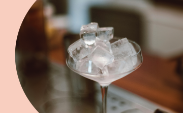 A close shot of a coupe glass filled with ice cubes