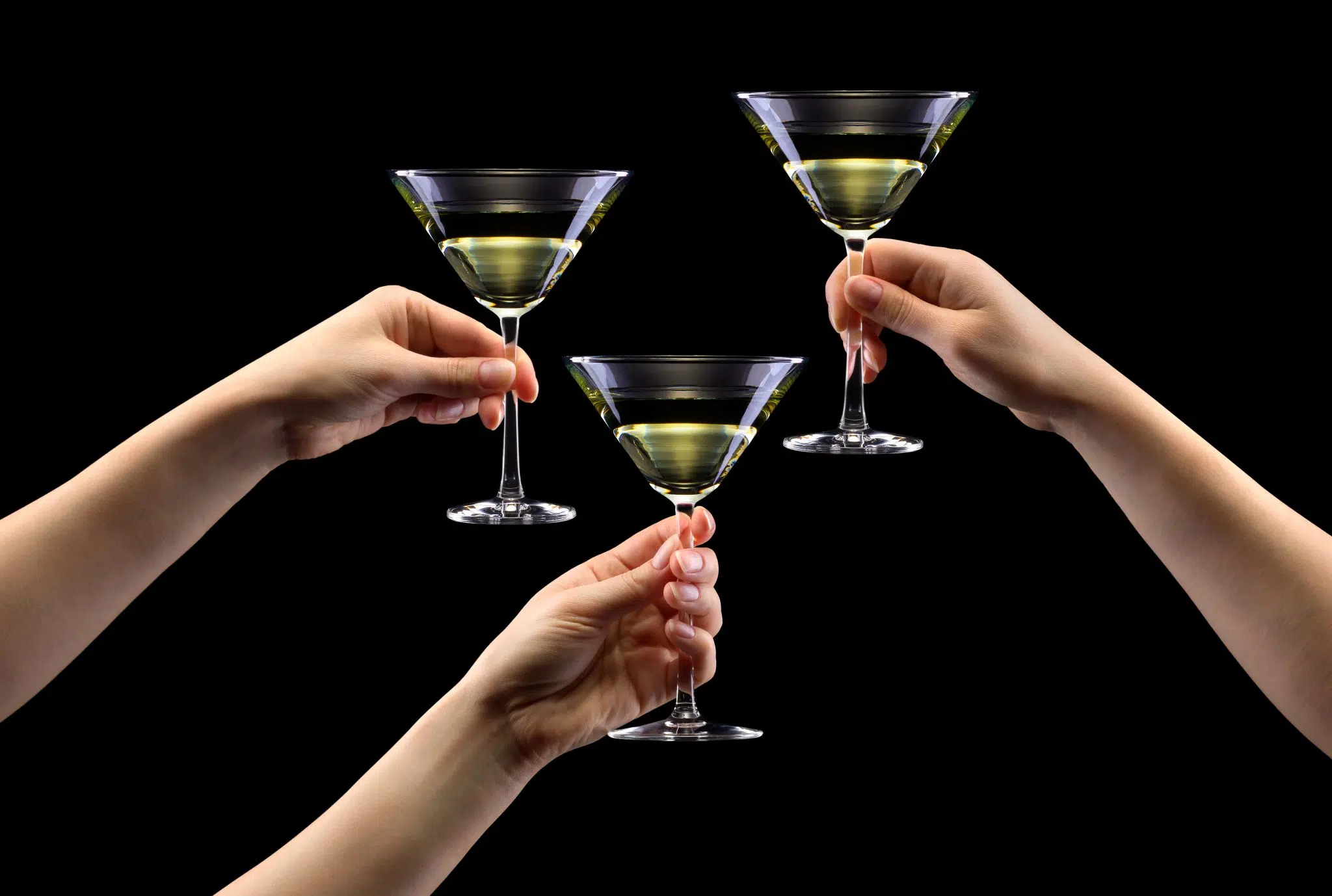 Three Martini glasses holded by the stems properly