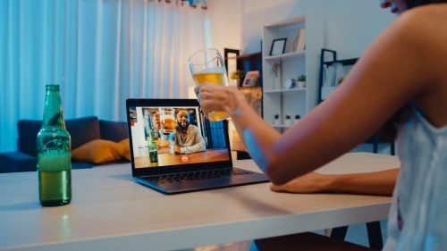 Woman cheersing with beer at home